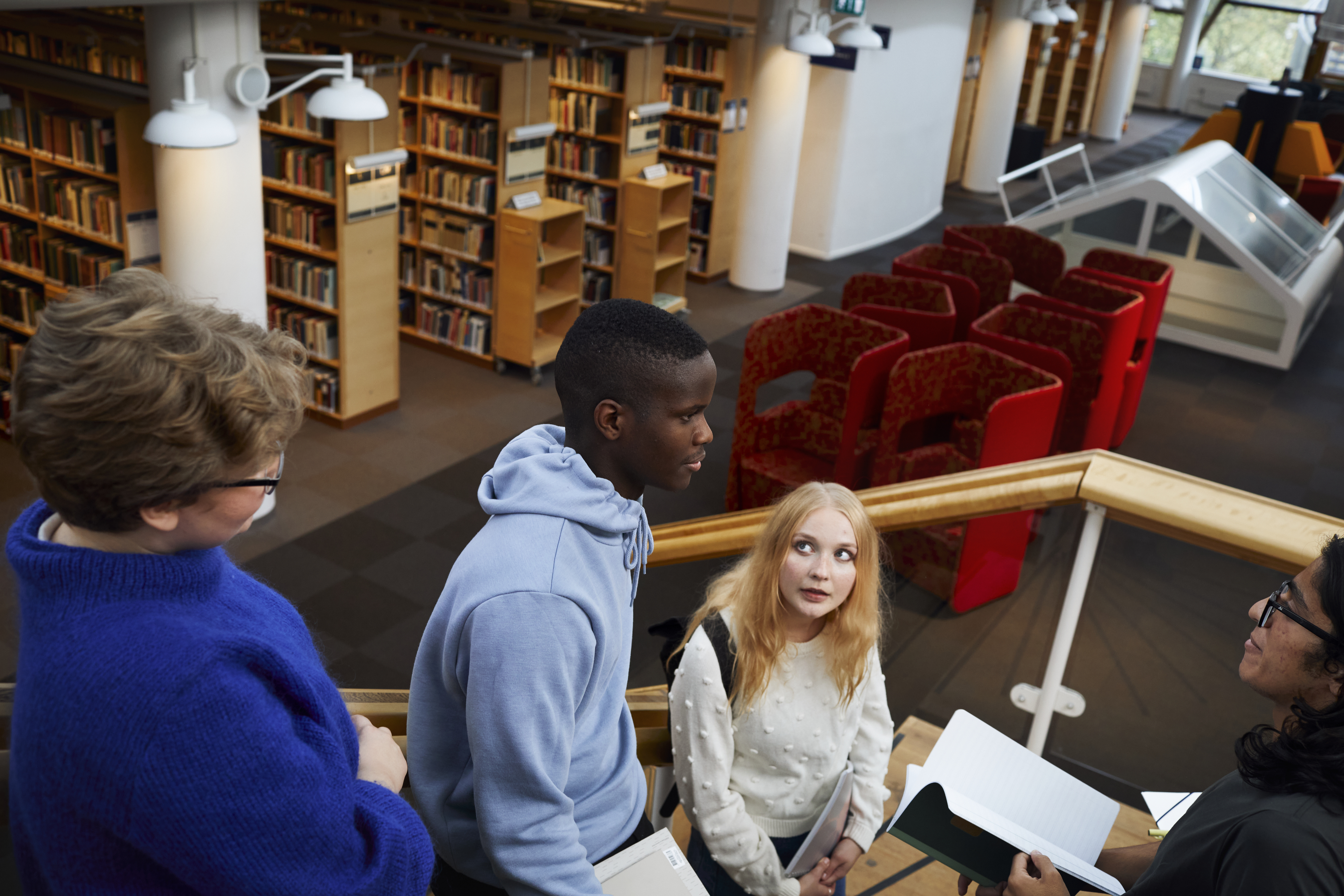 Fyra studenter i ett bibliotek